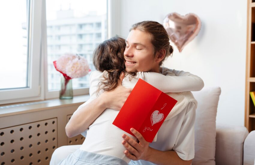 Couple hugging at home holding valentine. Love concept