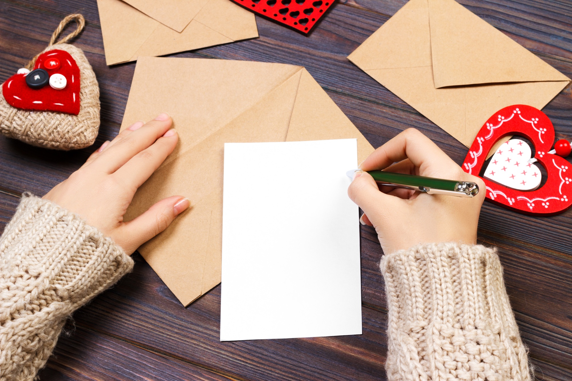 Woman writing love letter or romantic poem for Valentines day, top view of female hands