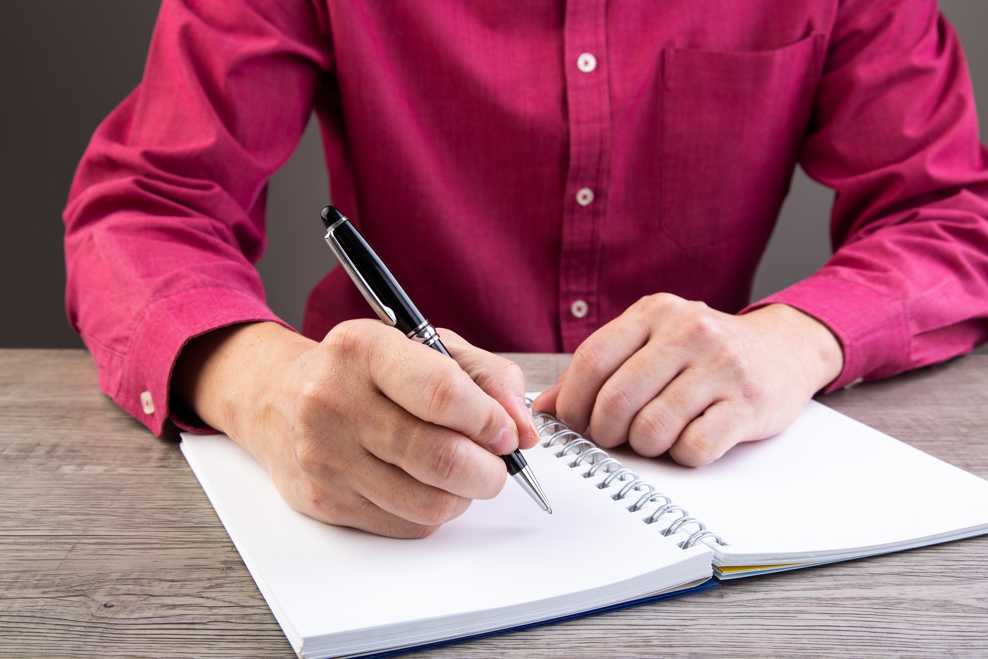 man writing on notebook